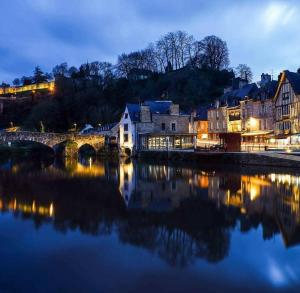 eine Stadt mit einer Brücke über einen Fluss in der Nacht in der Unterkunft Ker Jerome - Traditional Stone Breton Cottage near to Dinan in Trélivan