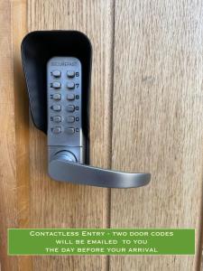 a remote control attached to a wooden door at Union Road Moto Velo Accommodation in Crediton