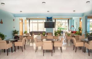 a waiting room with tables and chairs and a flat screen tv at Oasis Tigaki in Tigaki