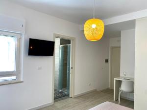 a white living room with a television and a window at Le Calette House - Puglia Mia Apartments in Monopoli