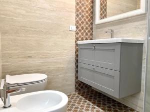 a bathroom with a white toilet and a sink at Le Calette House - Puglia Mia Apartments in Monopoli