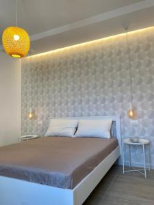 a bedroom with a large bed with a wall at Le Calette House - Puglia Mia Apartments in Monopoli