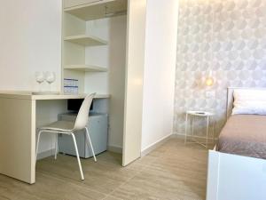 a bedroom with a desk and a bed with a chair at Le Calette House - Puglia Mia Apartments in Monopoli