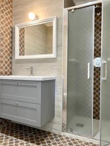a bathroom with a shower and a sink and a mirror at Le Calette House - Puglia Mia Apartments in Monopoli