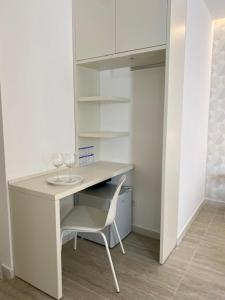 a white desk with a chair and wine glasses on it at Le Calette House - Puglia Mia Apartments in Monopoli