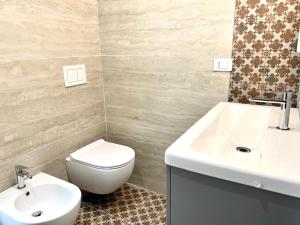 a bathroom with a white toilet and a sink at Le Calette House - Puglia Mia Apartments in Monopoli
