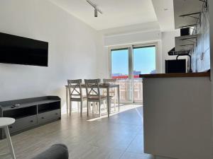a living room with a table and chairs and a television at Le Calette House - Puglia Mia Apartments in Monopoli
