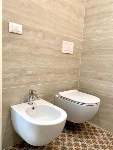 a bathroom with a white toilet and a sink at Le Calette House - Puglia Mia Apartments in Monopoli