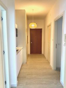a hallway leading to a kitchen with a brown door at Le Calette House - Puglia Mia Apartments in Monopoli