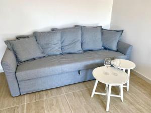 a blue couch in a living room with two tables at Le Calette House - Puglia Mia Apartments in Monopoli