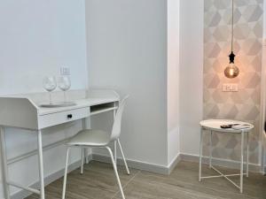 a white desk with two wine glasses and a stool at Le Calette House - Puglia Mia Apartments in Monopoli