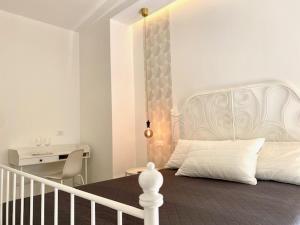 a white bedroom with a bed and a desk at Le Calette House - Puglia Mia Apartments in Monopoli