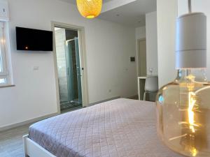 a bedroom with a bed with a vase on it at Le Calette House - Puglia Mia Apartments in Monopoli