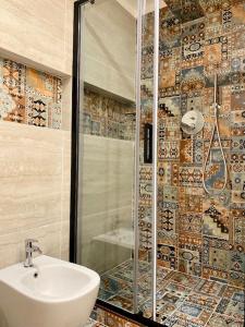 a bathroom with a sink and a glass shower at Le Calette House - Puglia Mia Apartments in Monopoli
