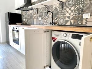 a kitchen with a washing machine under a counter at Le Calette House - Puglia Mia Apartments in Monopoli