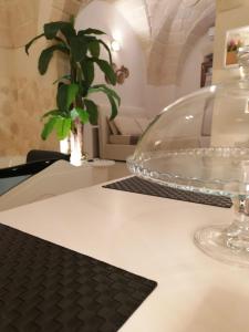 Suite il Vicoletto في Crispiano: وعاء زجاجي على طاولة مع منديل أسود