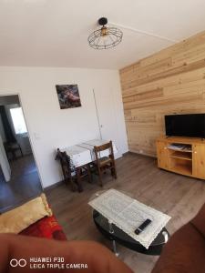 een woonkamer met een tafel en een televisie bij T2 cosy proche des pistes in Briançon