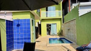 a house with a swimming pool next to a building at Shallow Beach in Búzios