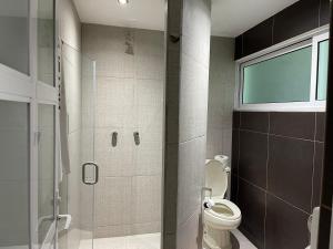 a bathroom with a toilet and a glass shower at Hotel Latino in Sahuayo de José María Morelos