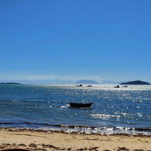 um barco sentado na água na praia em Shallow Beach em Búzios