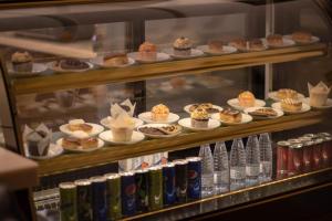a display case filled with lots of desserts and drinks at Awj Jazan Suites Hotels in Jazan