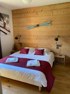 a bedroom with a large bed with a wooden wall at Luxury 2 Bedroom Apartment with view of Mont Blanc in Combloux