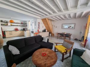 a living room with a black couch and a table at Maison avec terrasse au coeur de Sancerre in Sancerre