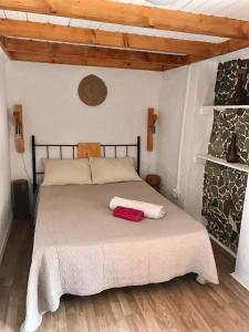 a bedroom with a bed with two towels on it at Thistle Cottage Alojamento Local in Gatas
