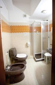 a bathroom with two toilets and a shower at Hotel Talao in Scalea