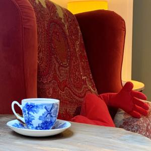 a cup sitting on a table next to a chair at b&b Meilrijk in Diest