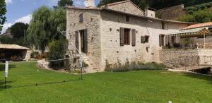 a large stone house with a grass yard at le moulin d'âne à niort in Niort +25 photos