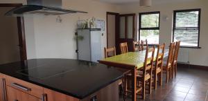 a kitchen with a black counter top and a table at Welcome Rest Holiday Home in Ballintoy