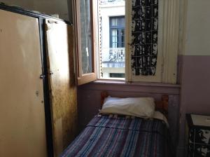 Cama pequeña en habitación con ventana en Hotel O'Rei en Buenos Aires