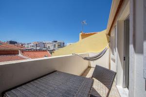 a balcony with a chair and a hammock on a building at Caparica Beach Apartment by HOST-POINT in Costa da Caparica