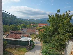 a group of houses on a hill with trees at Casa da Eira in Lobios