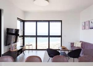 a living room with chairs and a large window at O&O Group- Modern Luxury APT-Mesmerizing Sea Views in Bat Yam