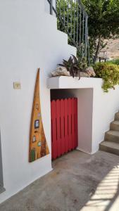 a wall with a surfboard next to a red door at Domatia me Thea in Elafonisos