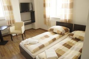 2 Betten in einem Zimmer mit einem Schreibtisch und einem Stuhl in der Unterkunft Pałacyk w Pakości Hotel in Pakość