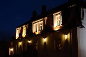 une maison avec des lumières sur son côté la nuit dans l'établissement Pałacyk w Pakości Hotel, à Pakość