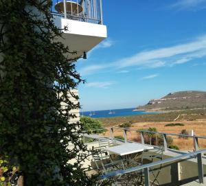a balcony with a table and chairs and the ocean at Domatia me Thea in Elafonisos