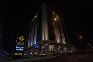 a building with a sign in front of it at night at فندق قوبا السويس in Jazan