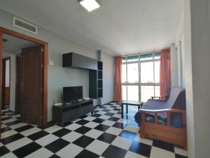 Pokój z podłogą wyłożoną szachownicą i sypialnią z łóżkiem w obiekcie Apartamento Juan Bautista w Maladze