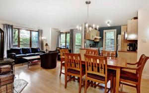 a kitchen and living room with a table and chairs at Chalets Alpins- 05 Chemin Alpin in Stoneham