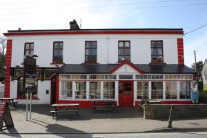 un edificio rosso e bianco con una porta rossa di Ravine Hotel a Lisdoonvarna