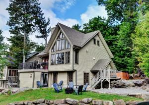 a house with chairs in front of it at Chalets Alpins - 56 Chemin des Skieurs in Stoneham