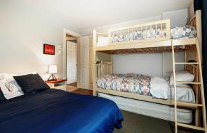 a bedroom with two bunk beds and a bed at Chalets Alpins - 56 Chemin des Skieurs in Stoneham +24 photos
