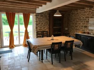 a dining room with a wooden table and chairs at LA GRANGE in Saint-Prix-lès-Arnay