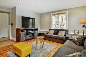 a living room with a couch and a tv at Chalets Alpins - 56 Chemin des Skieurs in Stoneham