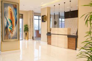 un vestíbulo de oficina con una pintura de un pavo real en فندق قوبا السويس, en Jazan