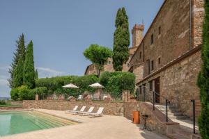 a swimming pool in front of a building at Castello Banfi - Il Borgo in Montalcino